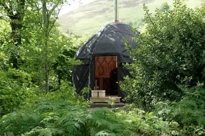 a black gazebo in the middle of a forest at Eastside Byre - Family cottage in the Pentland Hills near Edinburgh in Penicuik