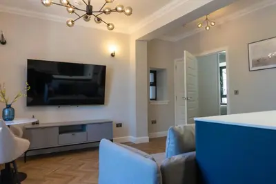 a living room with a flat screen tv on the wall at Oban Apartments in Oban