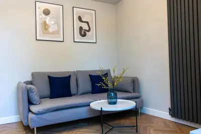 a living room with a blue couch and a table at Oban Apartments in Oban