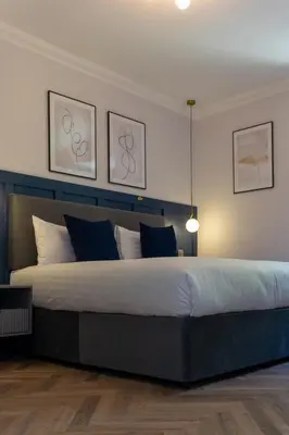 a bedroom with a large bed with blue and white pillows at Oban Apartments in Oban