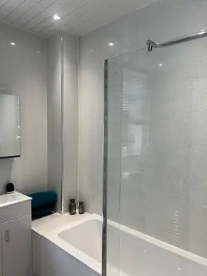 a bathroom with a tub and a glass shower at 1L Albert Place Maddiston Road Brightons Falkirk FK2 0JX in Polmont