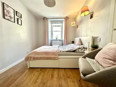 a bedroom with a bed with a window and a couch at City Centre Hidden Hideout for 2 in Edinburgh