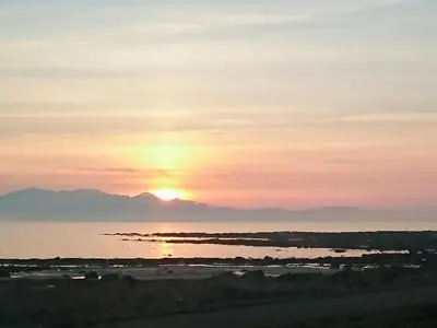 a sunset over the water with mountains in the background at Sorbie Villa in Stevenston