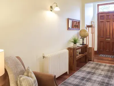 a living room with a radiator and a door at Sorbie Villa in Stevenston
