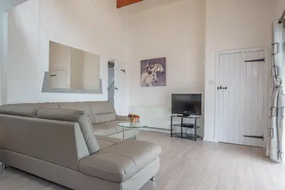 a living room with a couch and a tv at Thomas Carlyle Cottage in Thornhill