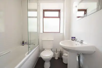a white bathroom with a toilet and a sink at Jane Welsh Cottage in Thornhill