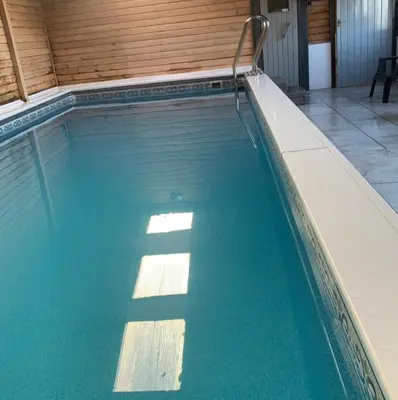 a swimming pool with blue water in a building at Morton Cottage in Thornhill