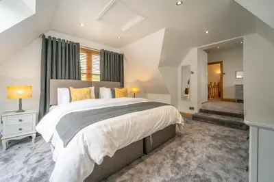 a bedroom with a large bed and a window at The Hoose at The Vu in Bathgate