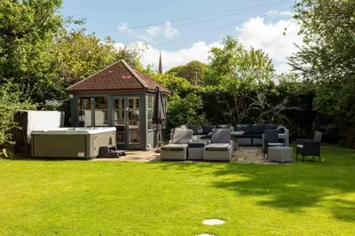 a backyard with a gazebo with couches and a table at Burnock Lodge with Hot Tub in Ayr