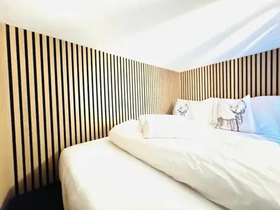 a bedroom with a white bed with a striped wall at City Centre Escape with Private Garden in Edinburgh