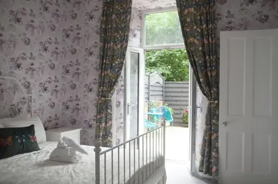 a bedroom with a bed and a window with curtains at City Centre Escape with Private Garden in Edinburgh