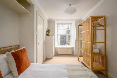 a bedroom with a bed and a book shelf at New Town Garden Retreat by Calton Living in Edinburgh