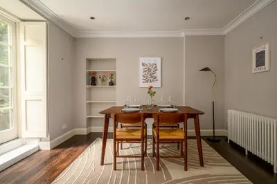 a dining room with a wooden table and chairs at New Town Garden Retreat by Calton Living in Edinburgh