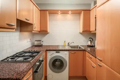 a kitchen with a washing machine and a sink at New Town Garden Retreat by Calton Living in Edinburgh