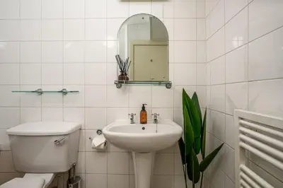 a bathroom with a sink and a toilet and a mirror at New Town Garden Retreat by Calton Living in Edinburgh