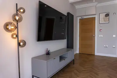 a living room with a tv on a wall at Oban Apartments in Oban