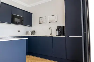 a kitchen with blue cabinets and a sink at Oban Apartments in Oban
