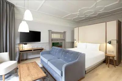 a hotel room with a bed and a blue couch at AC Hotel by Marriott Glasgow in Glasgow
