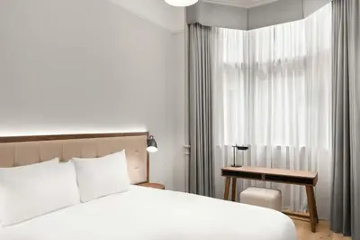 a bedroom with a bed and a desk and a window at AC Hotel by Marriott Glasgow in Glasgow