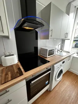 a kitchen with a counter top with a microwave at THE LAZY LION - Spacious 2 Bedroom - Town Centre Holiday Home Apartment in Port Glasgow