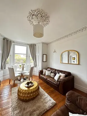 a living room with a couch and a table at THE LAZY LION - Spacious 2 Bedroom - Town Centre Holiday Home Apartment in Port Glasgow