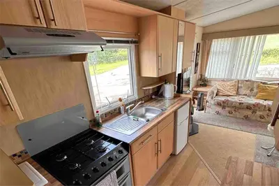 a kitchen with a stove and a sink in a caravan at 4-Bedroom Cosalt Located in Uddingston, Glasgow at Maryville Caravan Site in Uddingston