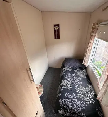 a small room with a bed and a window at 4-Bedroom Cosalt Located in Uddingston, Glasgow at Maryville Caravan Site in Uddingston