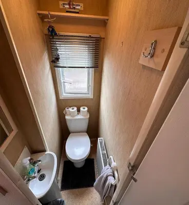 a small bathroom with a toilet and a sink at 4-Bedroom Cosalt Located in Uddingston, Glasgow at Maryville Caravan Site in Uddingston