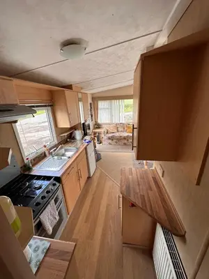 a small kitchen with a stove and a sink at 4-Bedroom Cosalt Located in Uddingston, Glasgow at Maryville Caravan Site in Uddingston