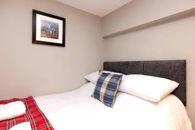 a bedroom with a bed and a picture on the wall at New Town Rooms in Edinburgh