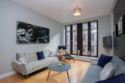 a living room with a couch and a table at Modern and refurbished Flat in Merchant City in Glasgow