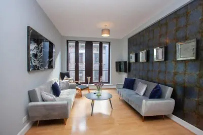a living room with two couches and a table at Modern and refurbished Flat in Merchant City in Glasgow