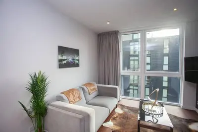 a living room with a couch and a large window at 1 Bedroom Apartment in Very Central Location in Glasgow