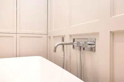 a shower in a bathroom with white cabinets at Deluxe 3-bedroom Apartment on Princes Street overlooking Edinburgh Castle in Edinburgh