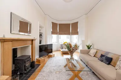 a living room with a couch and a fireplace at Tasteful 1-bedroom Apartment near Edinburgh Meadows in Edinburgh