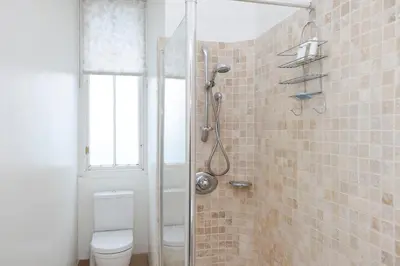 a bathroom with a shower with a toilet and a window at Tasteful 1-bedroom Apartment near Edinburgh Meadows in Edinburgh