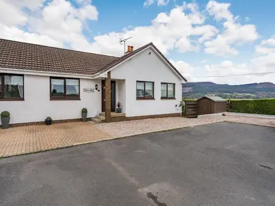 a white house with a driveway in front of it at Highview in Brodick