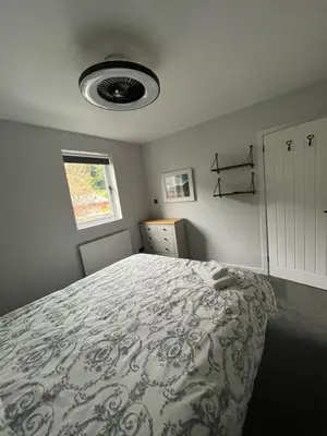 a bedroom with a bed with a comforter at The Mail Barn Studio in Lamlash
