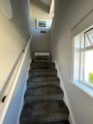a winding staircase in a house with a window at The Mail Barn Studio in Lamlash