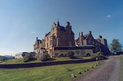 a bus parked in front of a large building at Loch Awe Hotel in Dalmally