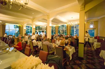 a group of people sitting at tables in a restaurant at Loch Awe Hotel in Dalmally