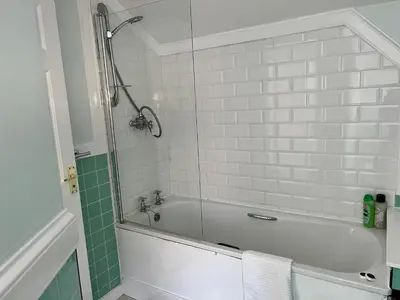 a bathroom with a bath tub with a glass shower at Very Central, Charlotte Square, near the Castle in Edinburgh