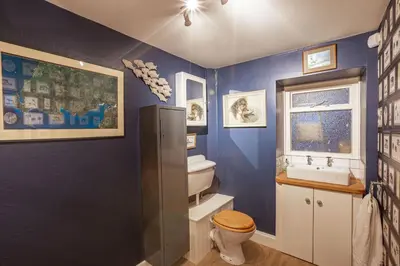 a blue bathroom with a toilet and a sink at Kenmure Kennels in New Galloway