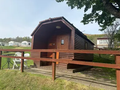 a small wooden dog house in a field at Cruachan Caravan and Camping Farm in Killin