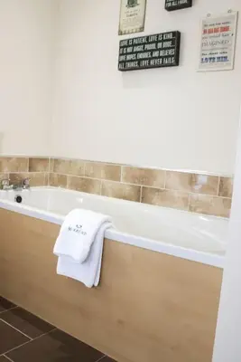 a bathroom with a bath tub with a towel on it at Pear Tree Cottage in Limekilns
