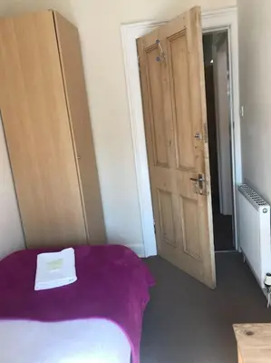 a bedroom with a purple bed and a wooden door at Central 3 bedrooms apartment for upto 6 in Edinburgh