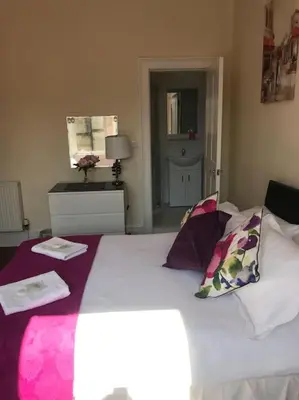 a bedroom with a large bed with purple sheets and pillows at Central 3 bedrooms apartment for upto 6 in Edinburgh