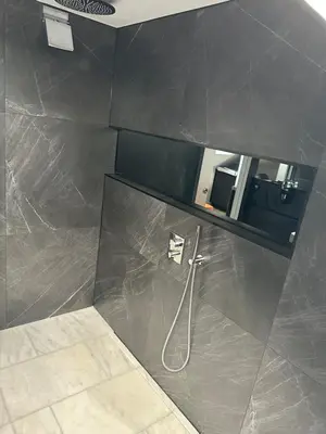 a bathroom with a shower and a mirror at Laurieston Penthouse in Grahamston