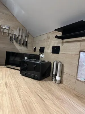a living room with a television and a wooden floor at Laurieston Penthouse in Grahamston