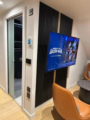 a living room with a flat screen tv on a wall at Laurieston Penthouse in Grahamston